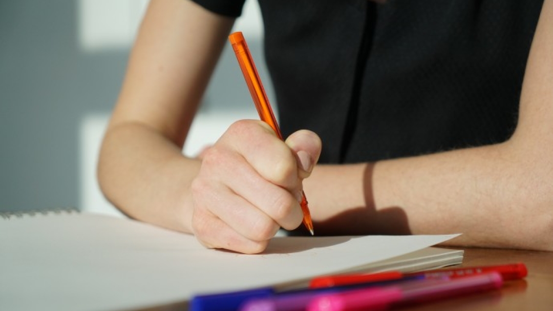 Student writing on paper
