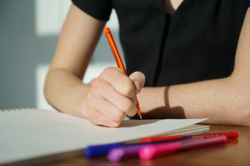 Student writing on paper